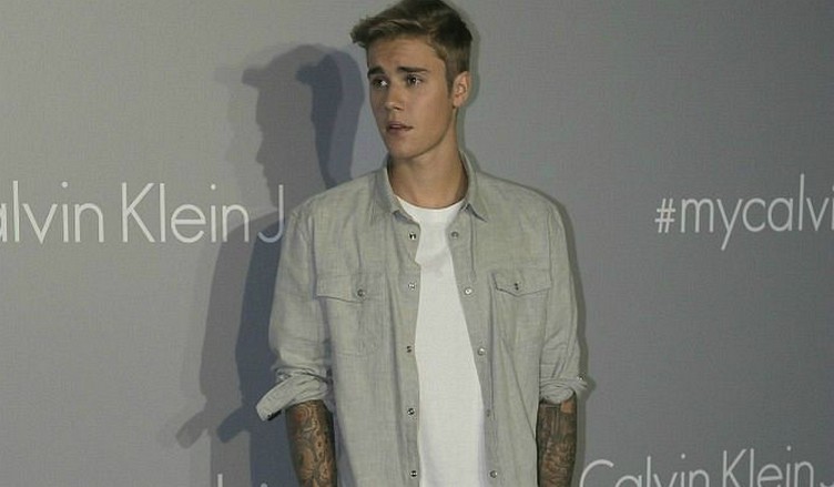Canadian singer Justin Bieber poses for photographers, upon arrival at the Calvin Klein promotional event, in Hong Kong, Thursday, June 11, 2015. (AP Photo/Vincent Yu)
