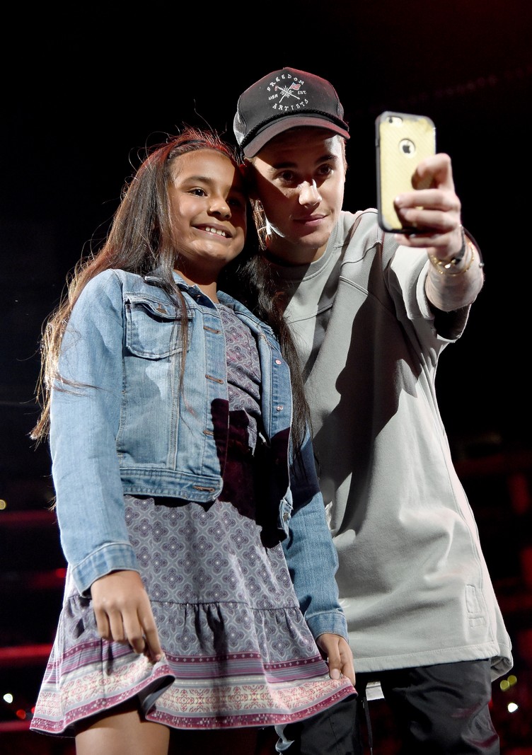 LOS ANGELES, CA - NOVEMBER 13: Singer/songwriter Justin Bieber takes a selfie with a fan onstage during An Evening With Justin Bieber at Staples Center on November 13, 2015 in Los Angeles, California. (Photo by Jason Merritt/Getty Images for Universal Music)