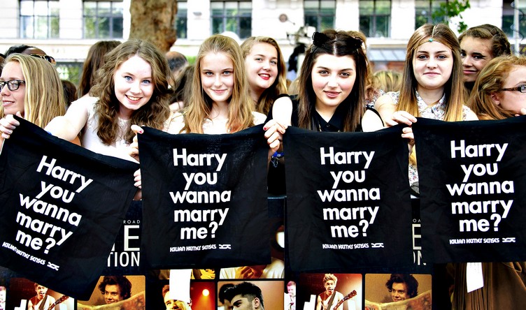 Fans of group One direction, display messages for Harry Styles, ahead of the UK Premiere of One Direction: This Is Us, at a central London cinema, Tuesday, Aug. 20, 2013. (Photo by Jonathan Short/Invision/AP)