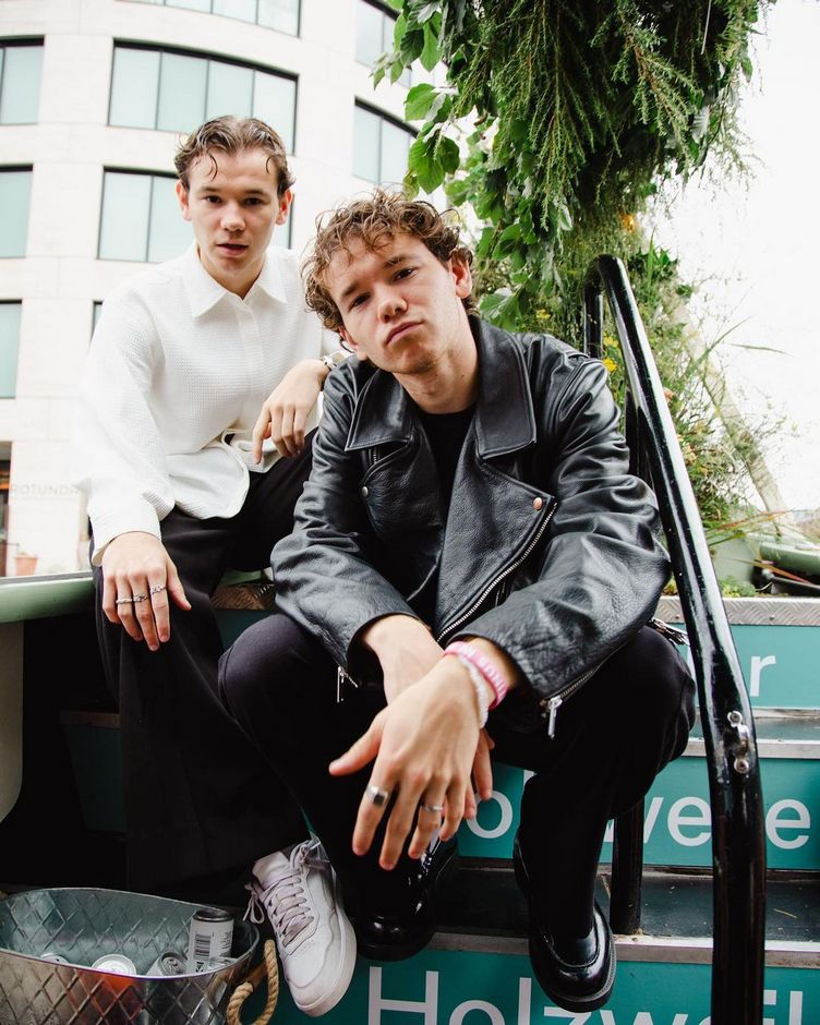 Marcus and Martinus posing while sitting on the stairs.